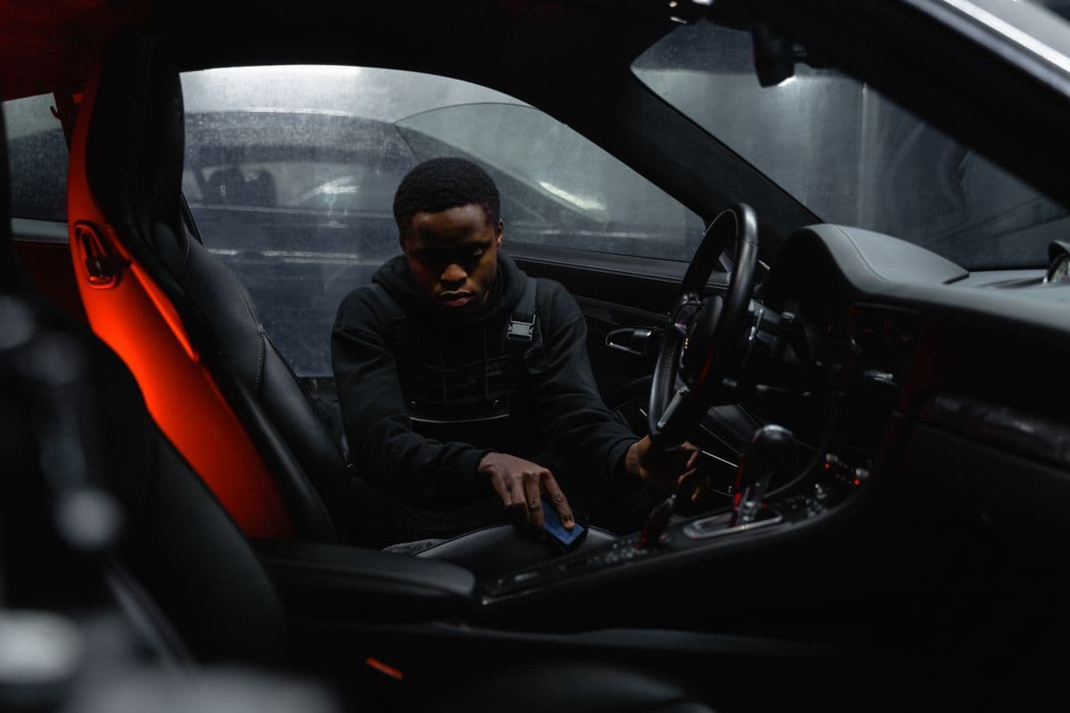 A detailer carefully cleaning a vehicle interior
